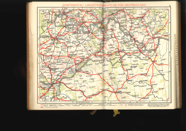 Offenes Buch mit einem detaillierten Kartenbild von Deutschlands Straßen und Autobahnen auf einem schwarzen Hintergrund.