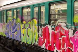 Ein Zug auf den Schienen mit zwei Personen im Inneren und Graffiti an der Außenseite.