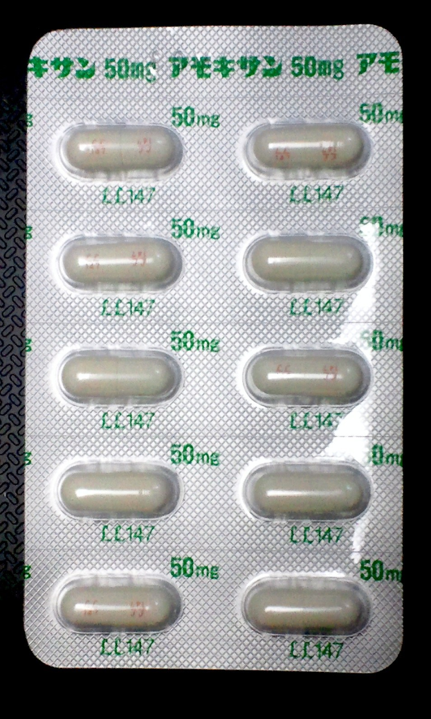 Blisterpackung weißer Pillen mit aufgedrucktem Text auf schwarzem Hintergrund.