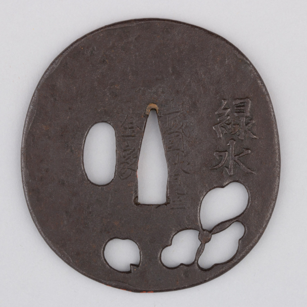 Runder japanischer Tsuba mit floralem Design und eingraviertem Text, vor einem weißen Hintergrund dargestellt.