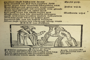 Ein Papier mit gedrucktem Text in einer unbekannten Sprache, mit zwei Männern daneben, möglicherweise aus einem Lehrbuch.