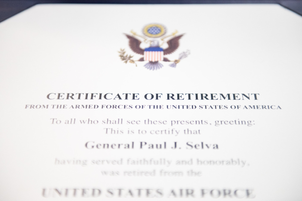 Rahmenurkunde der United States Air Force mit blauer Einfassung, zentralem Sternschild-Logo innerhalb eines Lorbeerkranzes und einer "Retirement"-Bannerschrift, alles in Schwarz gedruckt.