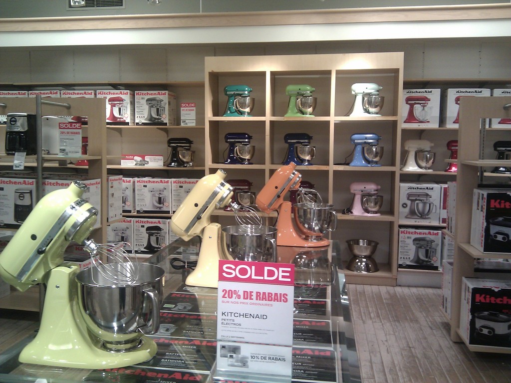 Mischmaschinen auf einer Glasoberfläche mit einer Platte und im Hintergrund mehrere Maschinen, Boxen auf Gestellen, eine Wand und ein Boden.