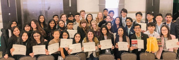 Fünf Personen mit Auszeichnungen und Urkunden auf einem Podium mit einem Banner "Welt-Kickbox-Meisterschaft Antalya 2019" im Hintergrund.