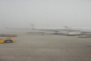 Ein Flugzeug und Fahrzeuge befinden sich auf einer Landebahn.