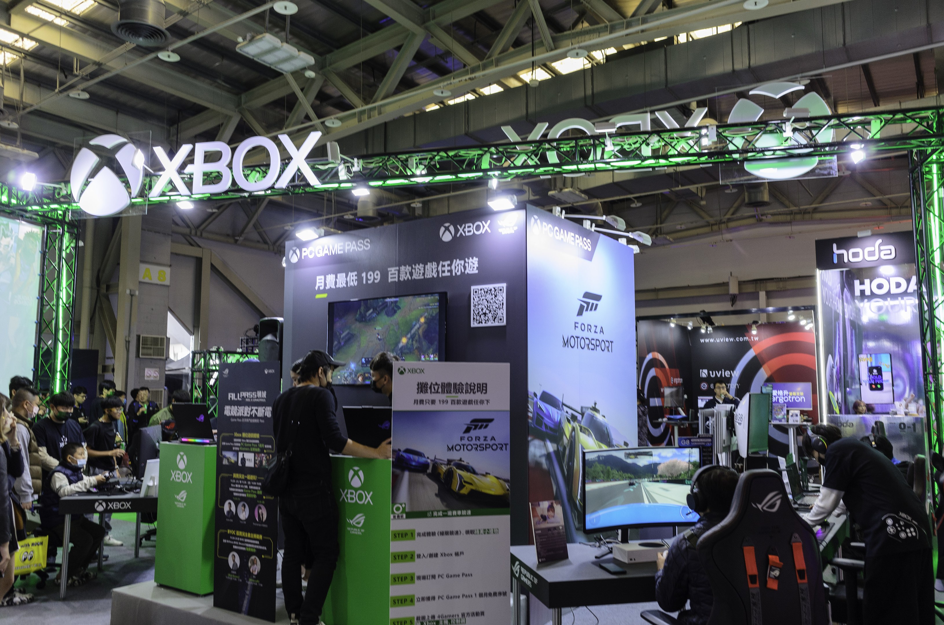 Eine Gruppe von Menschen auf einer Messe, die "Forza Motorsport 5 China" präsentieren.