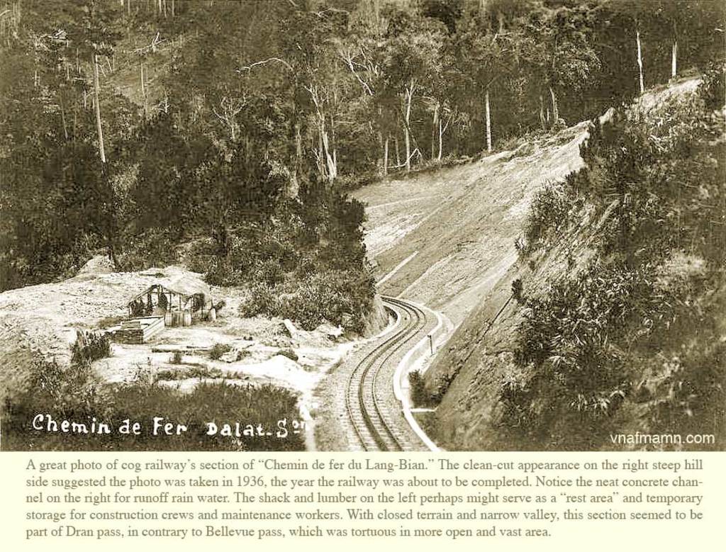Eine schneebedeckte Landschaft mit ein paar Bäumen, einer Hütte und einer Bahnlinie, mit einem Stück Papier, auf dem etwas geschrieben steht.