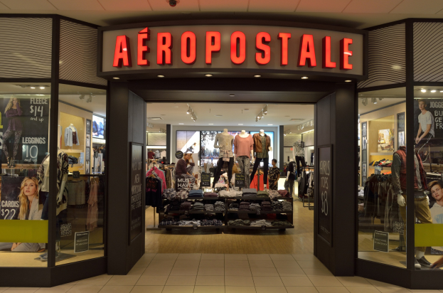 Aeropostale-Laden im Einkaufszentrum mit Kleiderstangen, Schaufensterpuppen in Kleidern, Informationsschildern, Glaswänden und Beleuchtung, der im Juni schließt.
