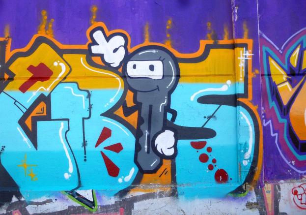 Eine farbenfrohe und bunte Graffiti-geschmückte Wand mit einem hellen Cartoon-Charakter, der in fröhlichen, bunten Farben gemalt ist.