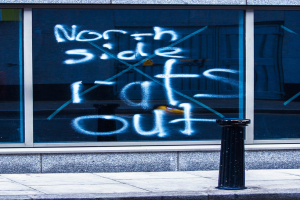 Text auf einem Fenster und einem Absperrpfahl auf der Straße.