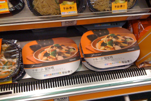 Essenskisten auf Regalen mit Preiszetteln.