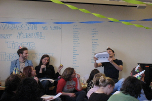 Eine Gruppe von Menschen feiert ihren ersten jährlichen Thesenvorfall, mit Bändern, die die Dachspitze schmücken und einige Personen tragen Mützen.